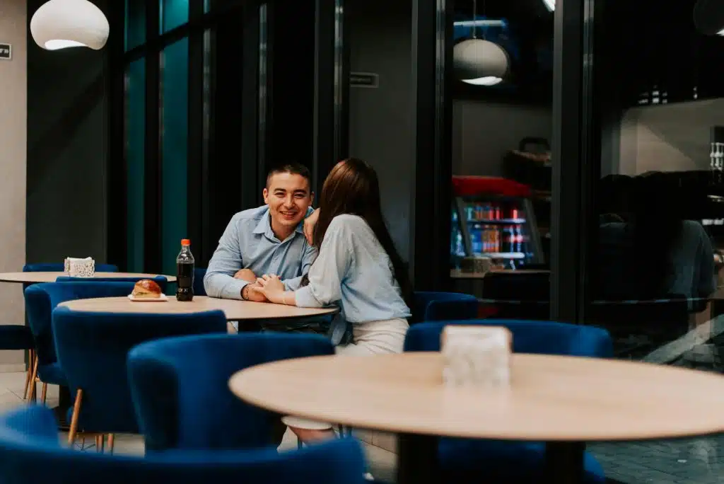 A man smiling while spending time with the woman in a restaurant.
