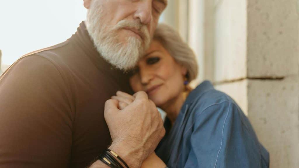 A couple embracing closely in soft sunlight.