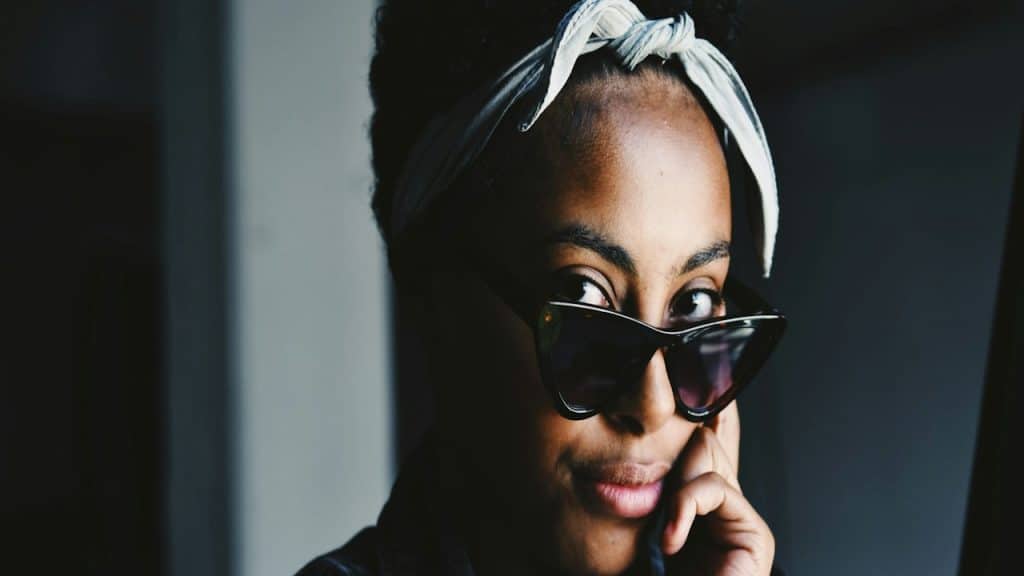 A woman wearing glasses standing in a room.