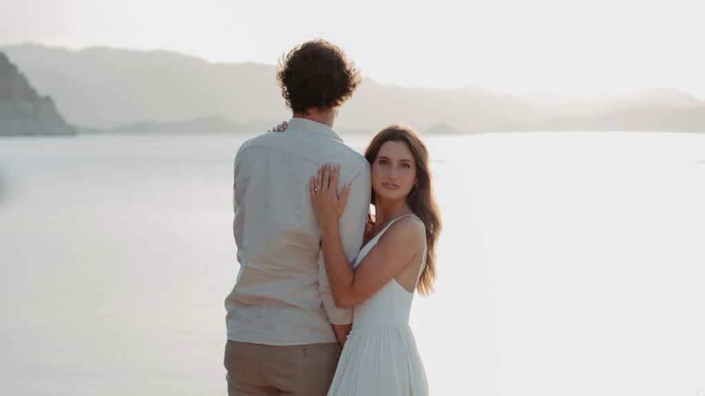 A man and a woman standing next to each other near a body of water.