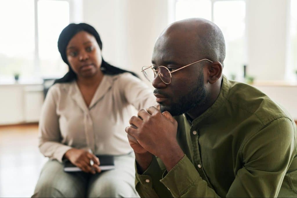 A woman reaching for a man’s shoulder