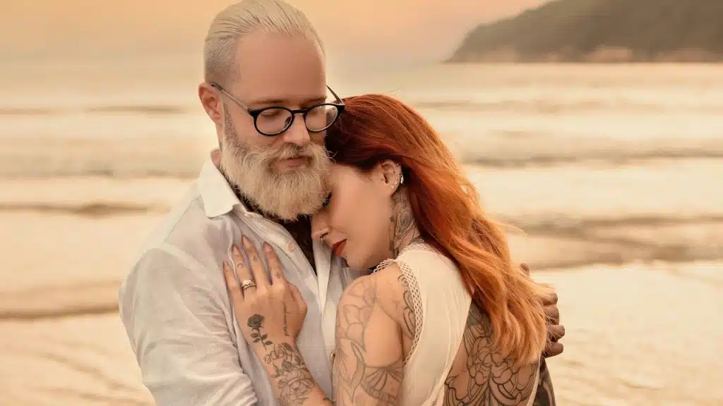 A man and a woman hugging on a beach.