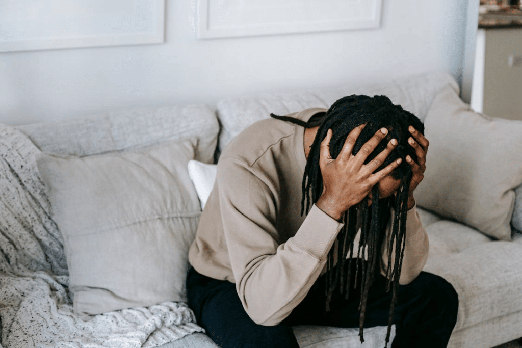 Stressed black man sitting on couch