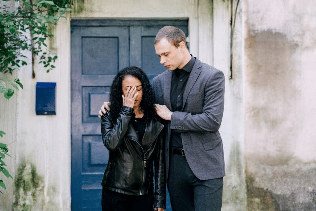 A man comforting a woman in black leather jacket