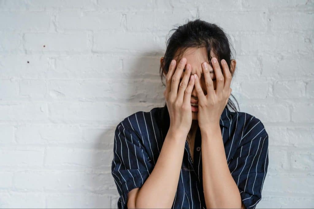 A woman crying and covering her face