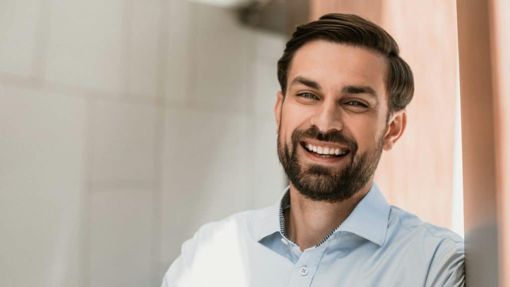 A bearded man smiling widely.