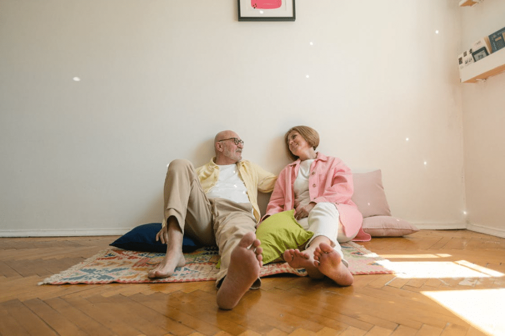 An elderly couple sitting on the floor