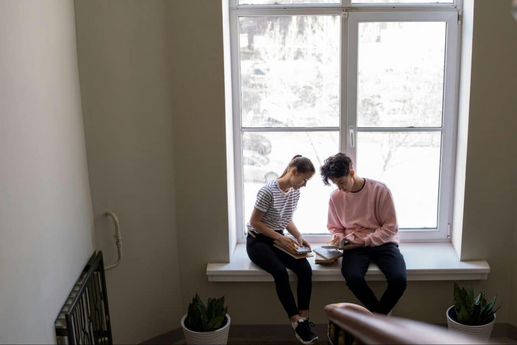 A man and woman sitting by the window
