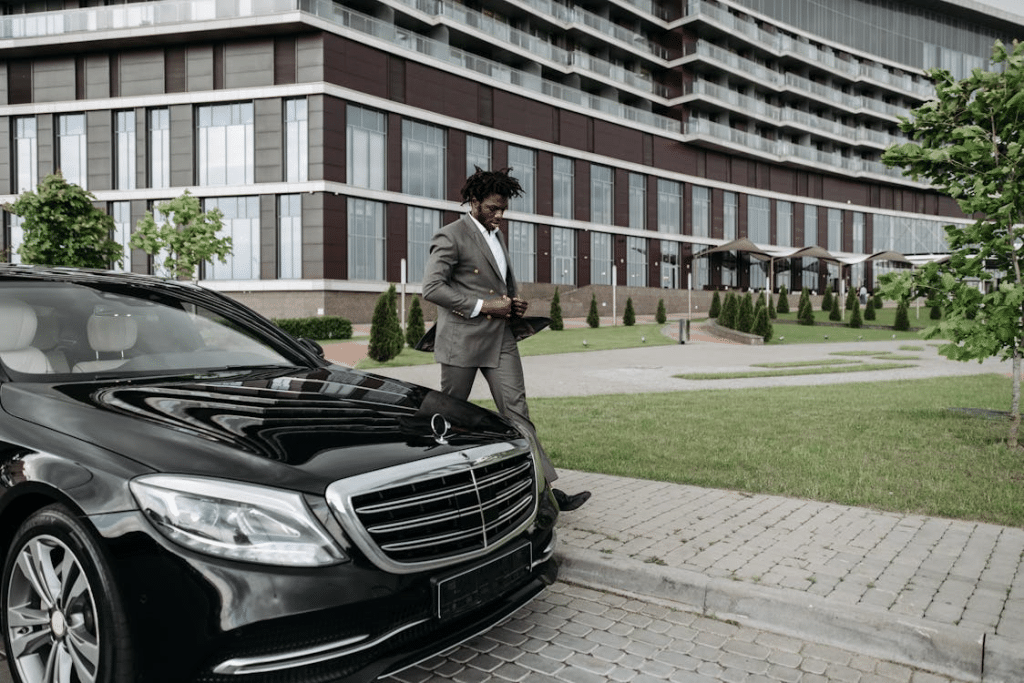 A man walking beside a black car