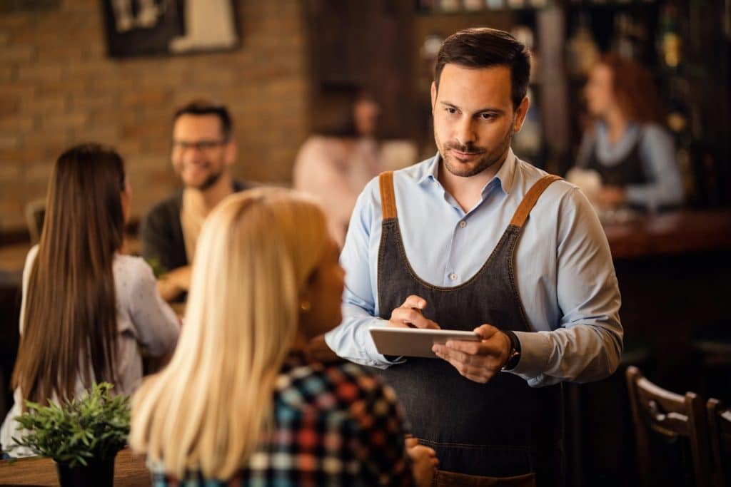 A waiter taking an order at the bar.