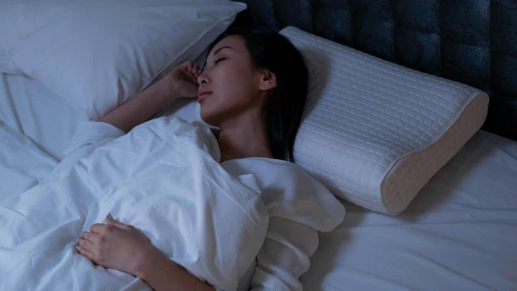 A woman sleeping peacefully in bed at night.