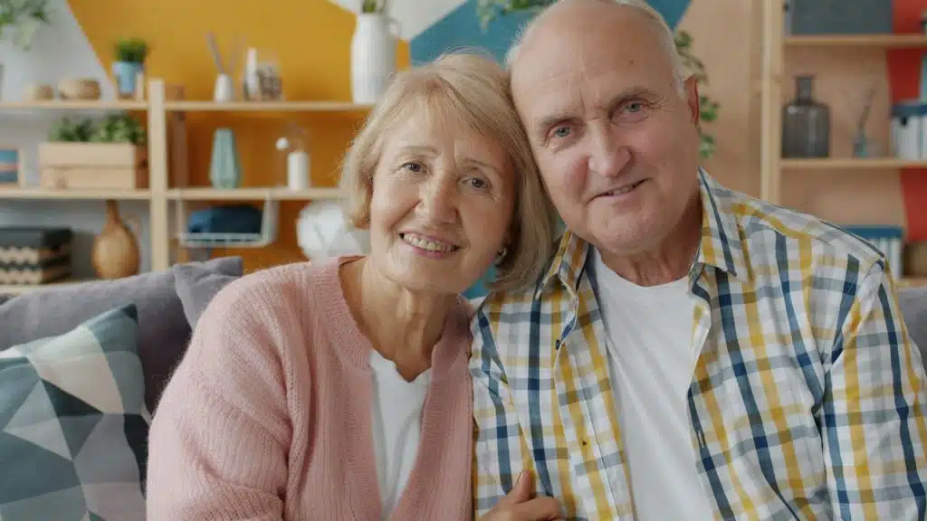 An older couple sitting together and smiling.