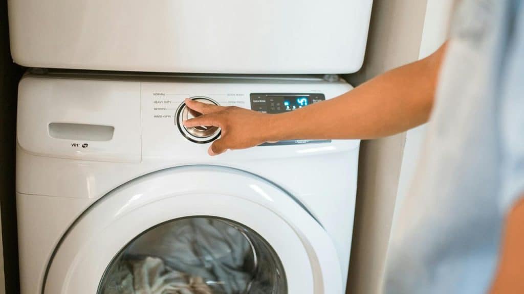 A person adjusting the settings on a washing machine.