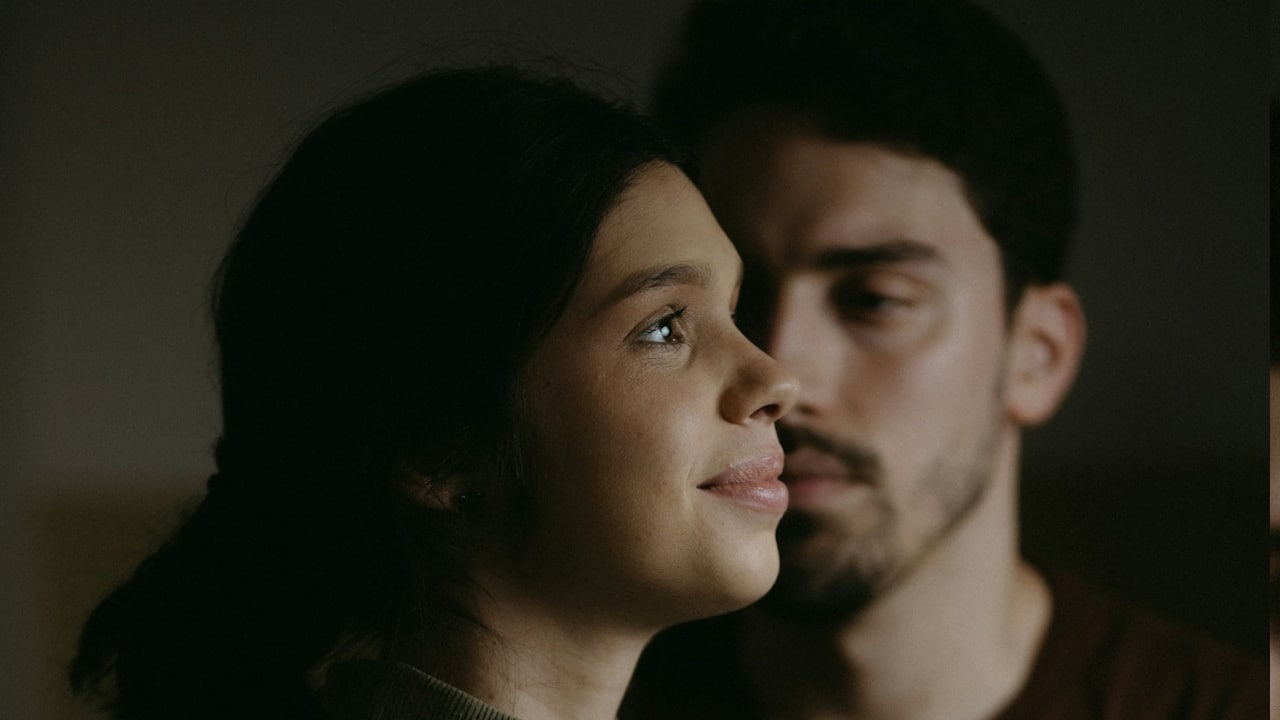A man and a woman sitting next to each other.