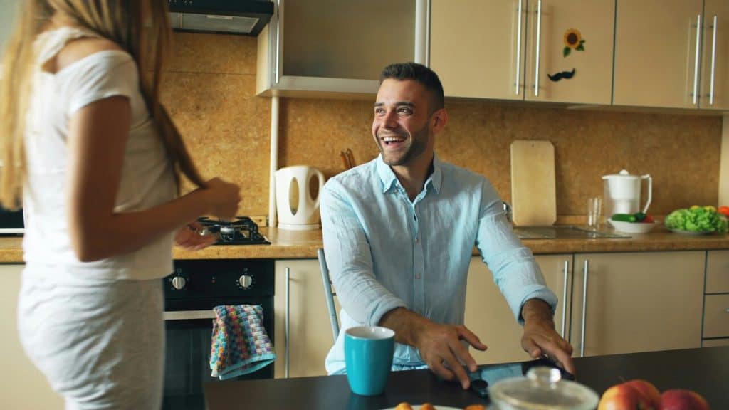 A couple laughing together in the kitchen
