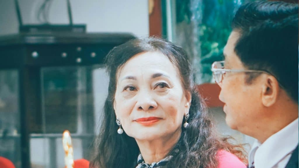An elderly couple is sitting in a family gathering.