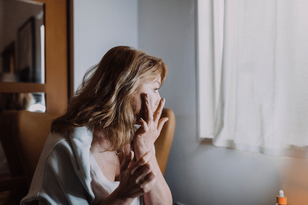 A Woman Wearing a White Blazer Holding Her Face
