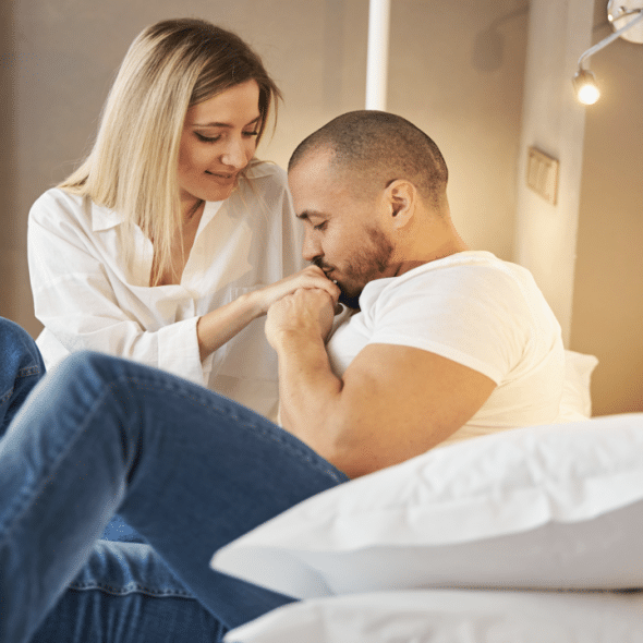 A man kissing his wife’s hand