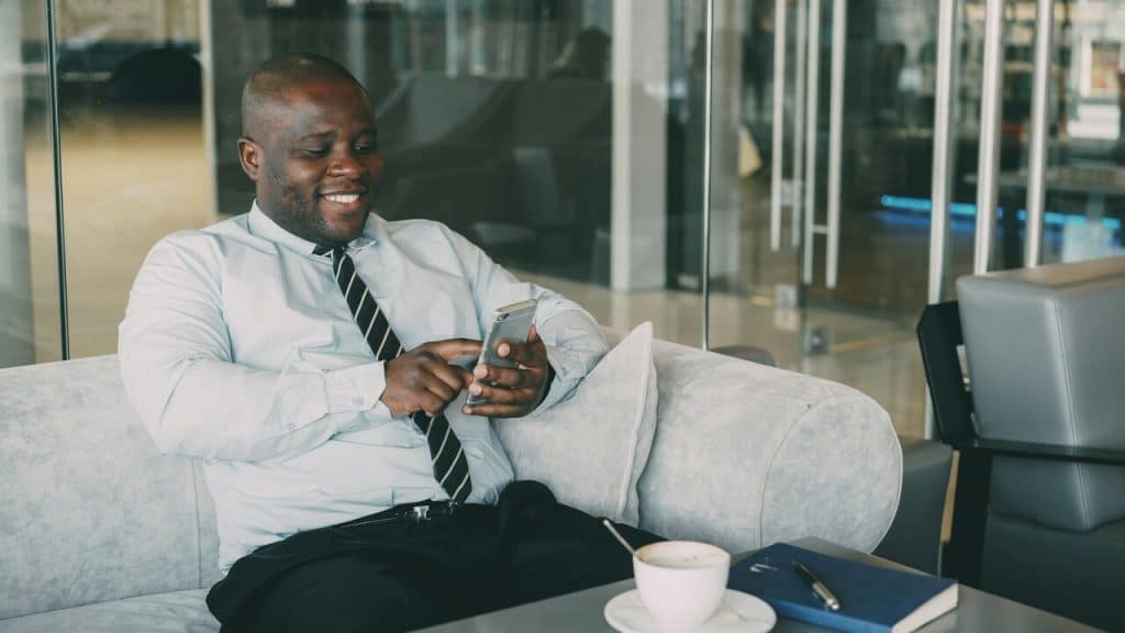 A man smiling while texting