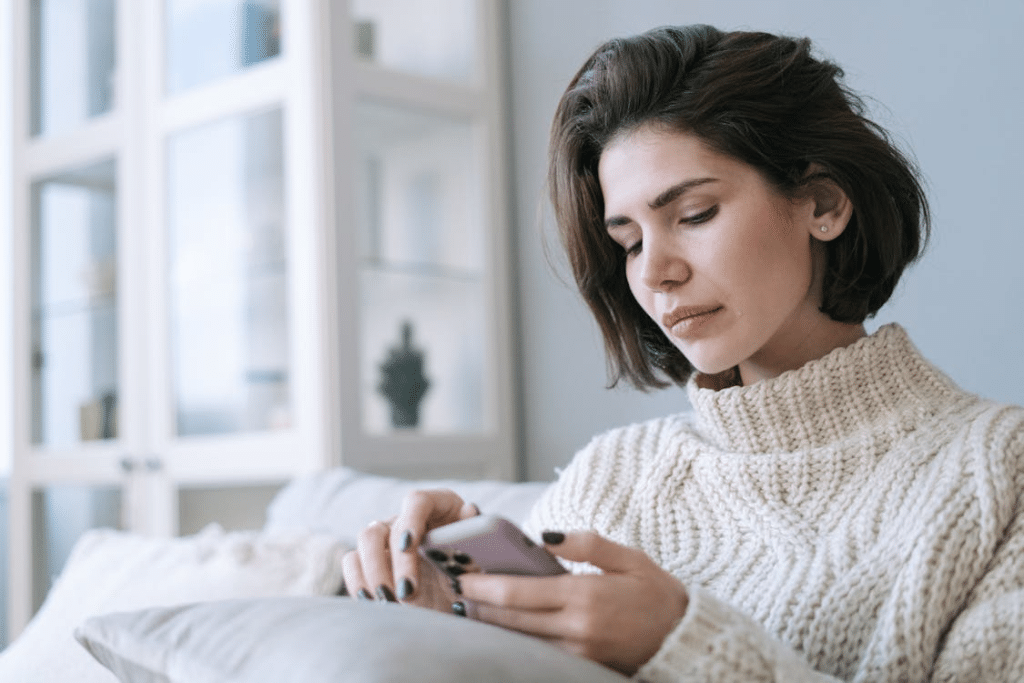 A sad woman using a phone