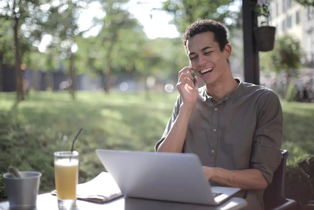 A man laughing while on a phone