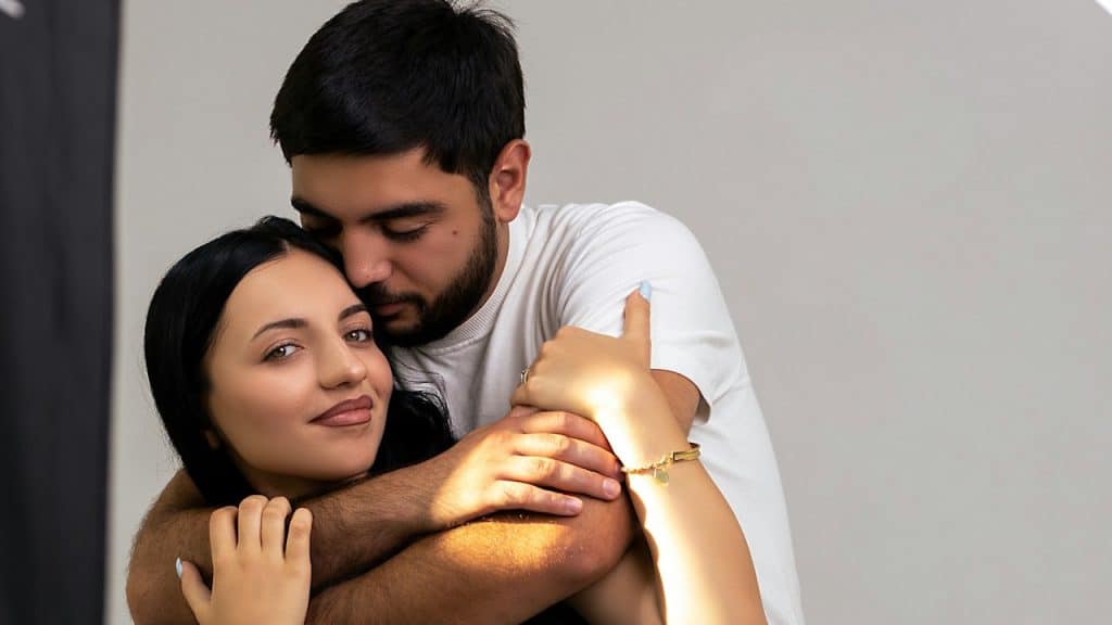A loving couple embraces each other affectionately.