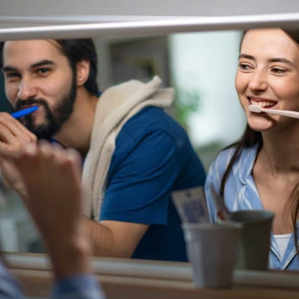 A couple brushing their teeth together