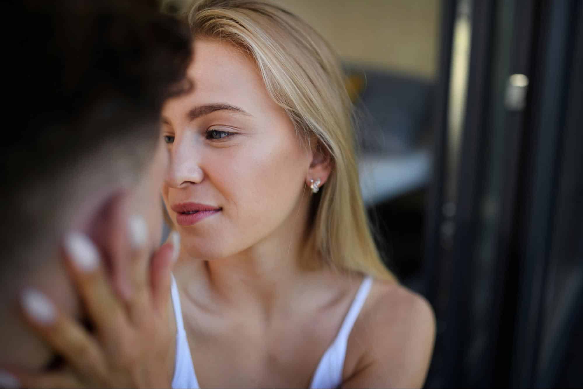 A woman holding a man’s face 
