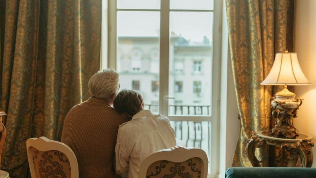 A couple sitting together and looking out a large window.