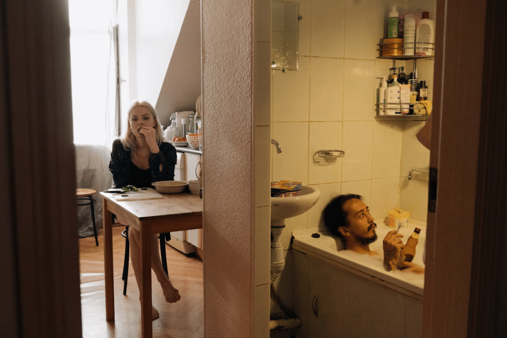 Woman on Kitchen with her Partner on Bathtub