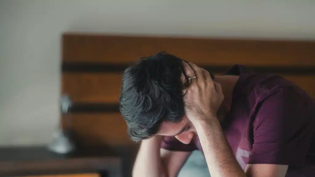 A man looking frustrated in the bedroom
