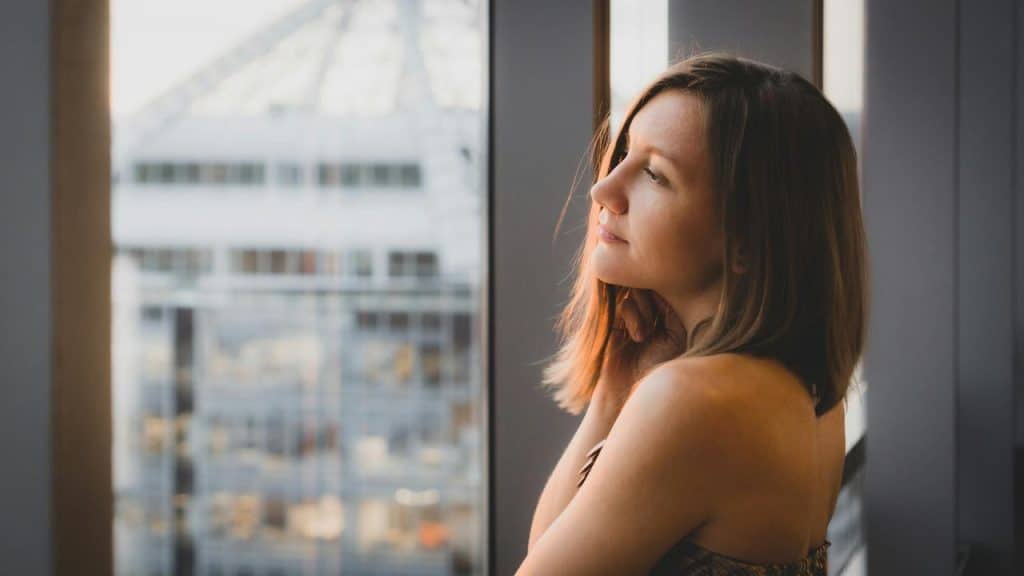 A woman looking out a window with a soft smile.
