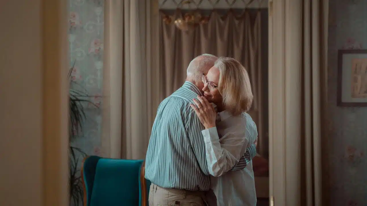 A couple embracing softly in a cozy room.