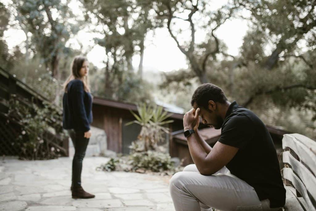 A woman looking at the man crying.