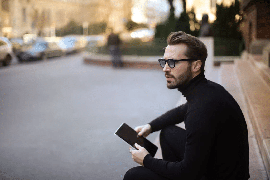 Pensive troubled stylish man with notepad on street