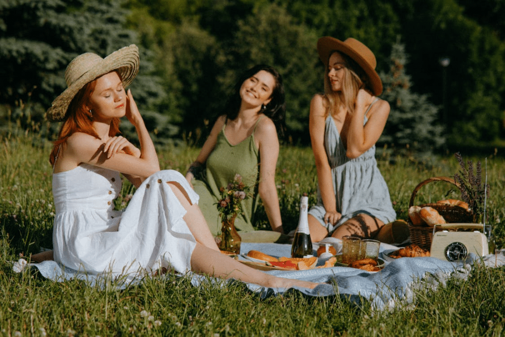Women in Sleeveless Dress Sitting on Picnic Blanket