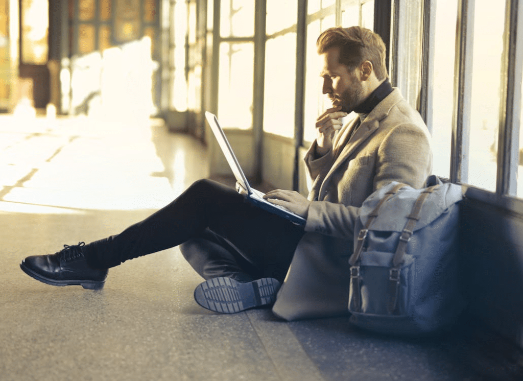 A man sitting on the floor using a laptop