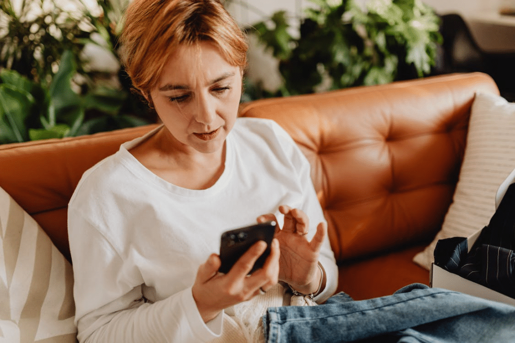 A woman using a phone on a couch