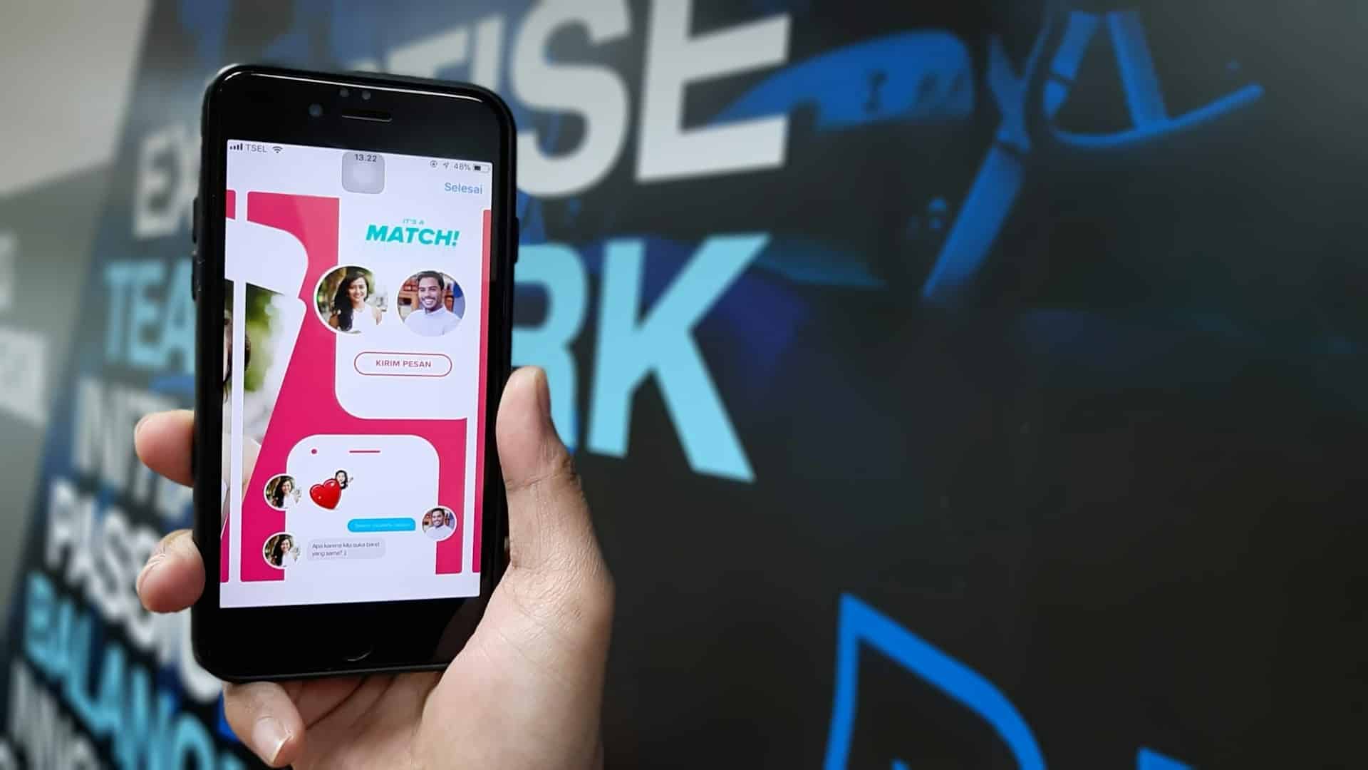 A man holding a smartphone with an opened dating app