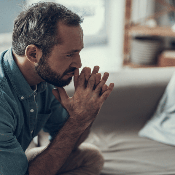 A man looking sad and thoughtful at home