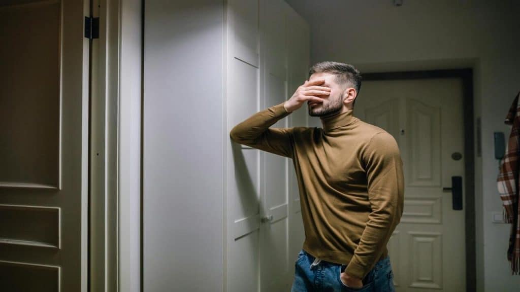 A man with his hand on his face