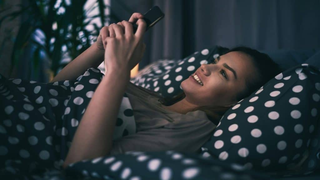 A woman texting late at night
