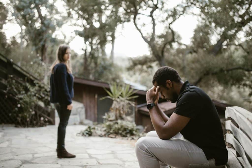 A woman looking at the frustrated man.