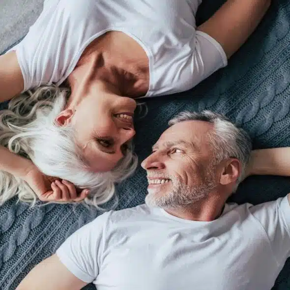 A couple looking at each other in bed