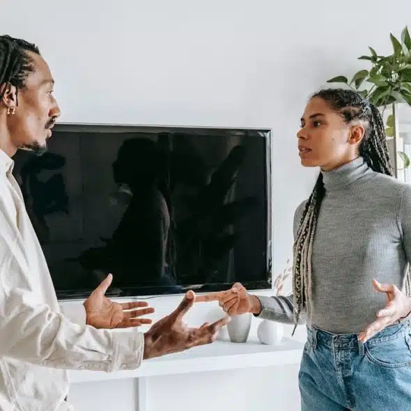 Black couple having a tense discussion or argument in a living room.