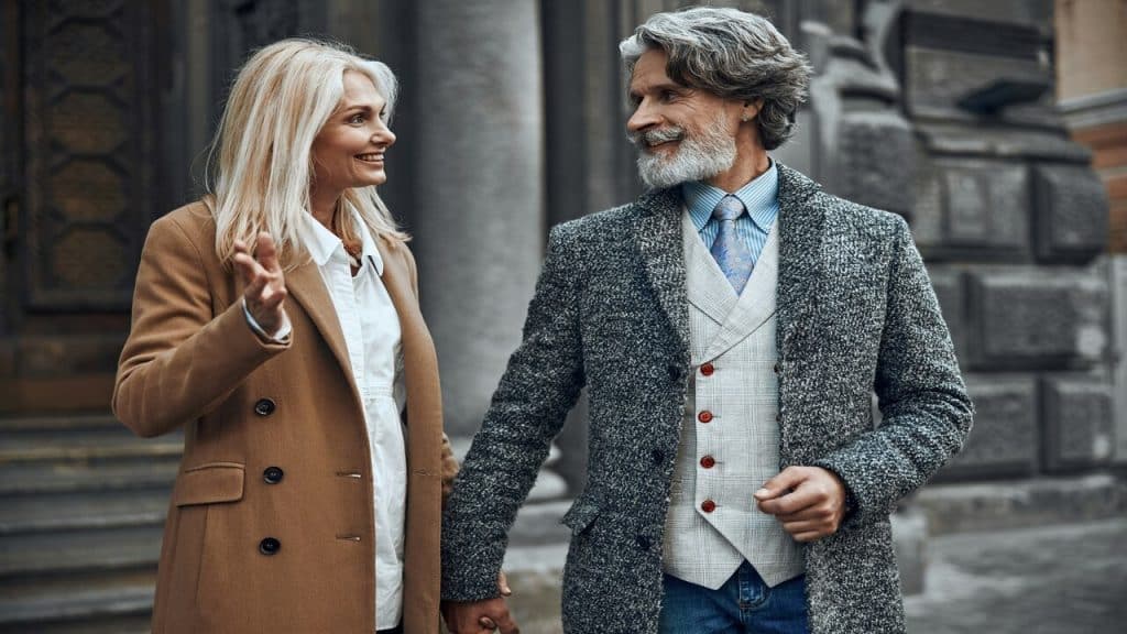 A mature couple holding hands outdoors