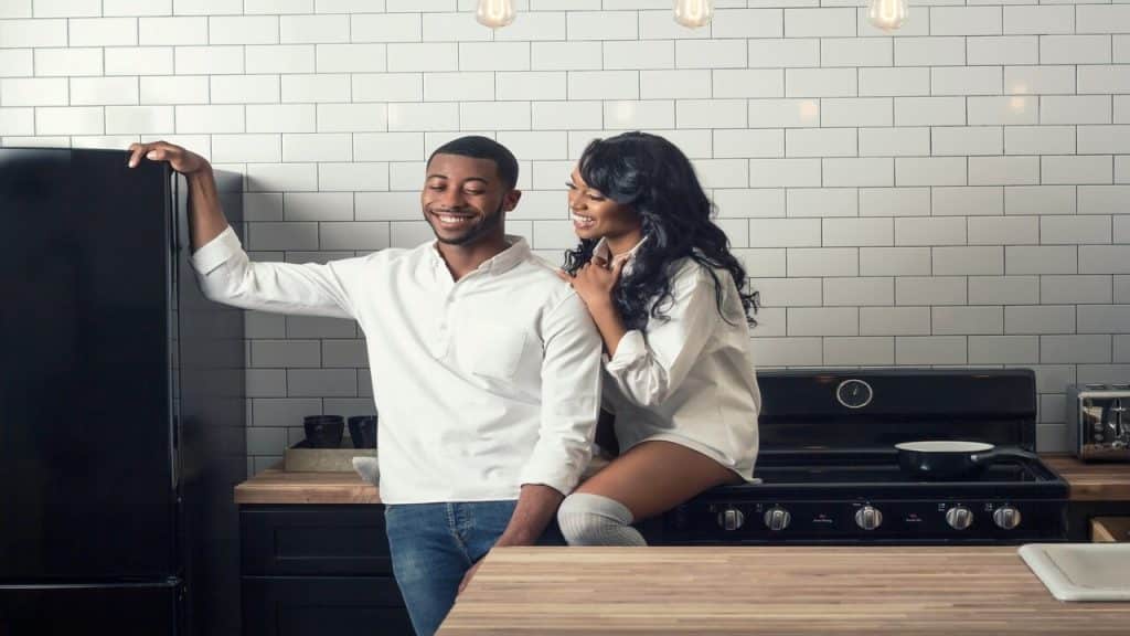 A couple laughing in the kitchen