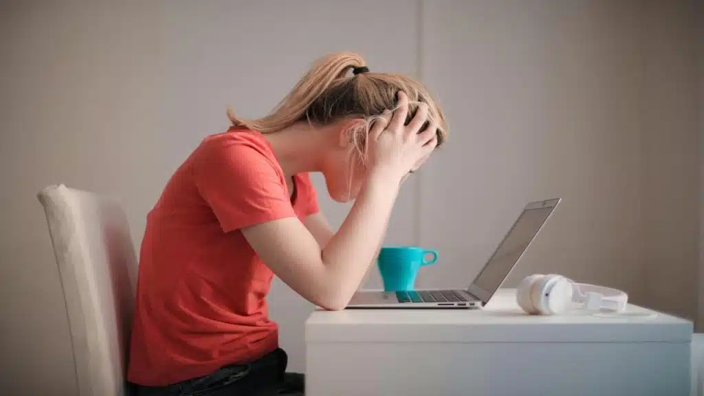 A woman looking stressed in front of her laptop