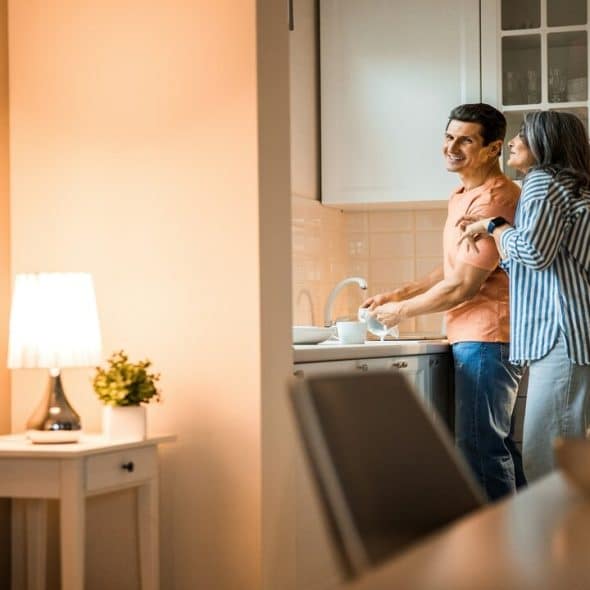 A couple laughing in the kitchen together