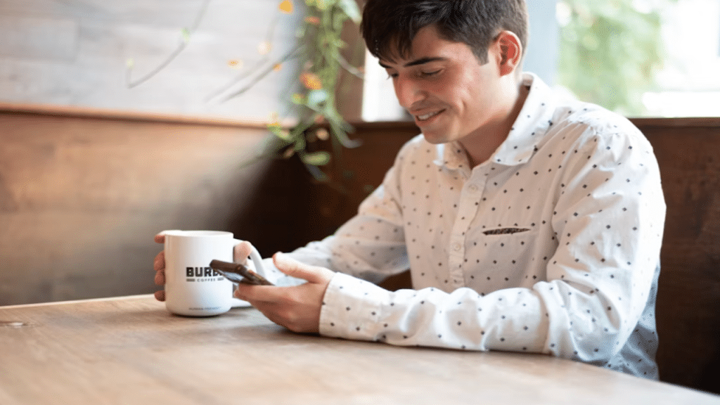 A man smiling while texting